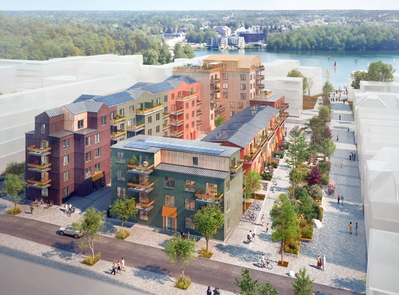 VYN vid Väsjö Torg från luften, träfasader i varma kulörer, solceller på taken och Väsjön bakom.